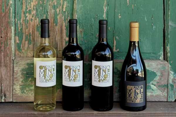 Four Casino Mine Ranch wines in front of a rustic green painted wooden door.