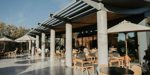 Casino Mine Ranch Tasting Room patio with people on sitting on arm chairs.